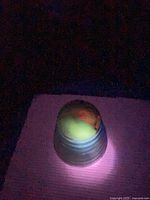 Planter glowing green under UV light, showing uranium content