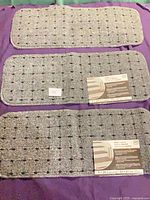 Three grey carpet stair treads with labels