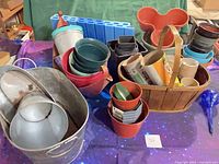 Overview of assorted planters, metal tub, wooden basket, blue kneeling pad