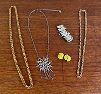 All five jewelry items laid out on wood surface