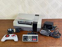 Console, controllers, power adapter, RF switch cable on table