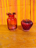 Vase and paperweight side by side on wooden surface