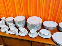 Overall view of stacked plates, bowls, cups, creamers in Holbrook pattern