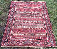 Full view of entire Persian Rahrah kilim rug laid flat on grass