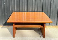 Front view of square teak coffee table with shelf