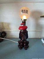 Full lamp showing ceramic dog base and globe shade