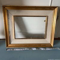 Full view of gold wood frame with tape measure indicating size