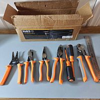 All seven insulated Klein tools lined up with original box in background