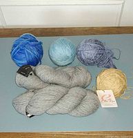 Group view of six yarn skeins/balls on table