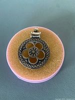 Front view of sterling silver floral pendant on foam pad