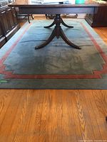 Full view of blue and rose Kashmiri area rug under dining table