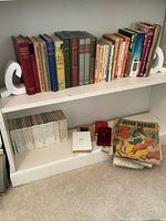 Wide view showing both shelves with assorted books and marble bookends