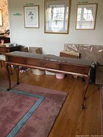 Front view of wood console table showing drawer and cabriole legs