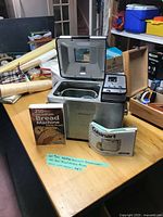 Full lot with bread maker, cookbook and manual on table