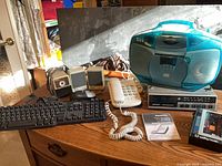 Group shot showing phone, boombox, keyboard, speakers, webcam, stereo component, pencil sharpener