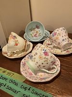 Overall view showing four teacups with saucers on table