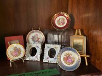 Group view of all Limoges frames and plates on shelf