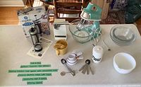 All items grouped on countertop showing mixer, can opener, cookie press, bowls and utensils
