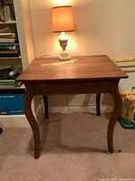 Side table with lamp positioned on top