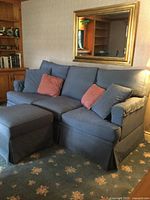 Front view of blue sofa with ottoman and cushions