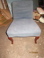 Front view of blue armless chair with slipcover and cabriole legs