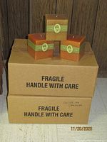 Two large shipping cartons marked fragile with three square candles on top