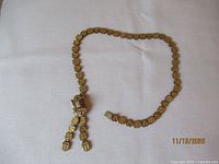Full view of necklace showing book chain and tassels
