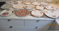 All 14 floral bone china plates displayed on countertop