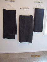 Three dark wool camp blankets hanging on hangers