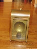 Front view of brass carriage lantern showing glass panel and bulb holder