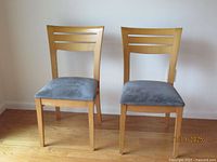 Front view of two Loewenstein cherry wood side chairs with blue cushions
