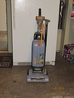 Front view of Hoover upright vacuum with attachments