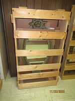 Mirror secured in wooden shipping crate showing overall size and oval shape