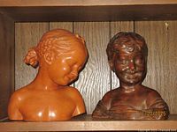 Both busts side by side on shelf