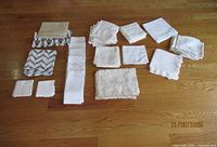 All stacks of napkins, folded table runner and fish mat arranged on floor