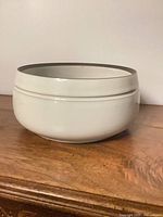 Side view of beige stoneware bowl with brown rim