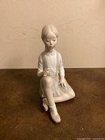 Front view of Lladro figurine seated girl holding flower
