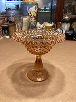 Full view of peach-amber Fenton hobnail pedestal comport on table