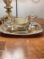 Side view of silver-plated gravy boat on underplate