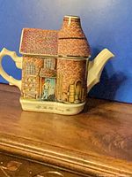 Front view of Sadler The Old Pottery teapot showing full building shape, handle and spout