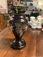 Full view of dark olive green cut-to-clear Bohemian vase on table