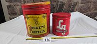 Front view of both tins with tape measure and lot marker