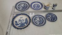 All seven Blue Willow pieces with rulers for scale