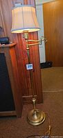 full view of brass floor lamp with shade and swing arm