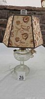 Lamp with shade attached showing embroidered pattern