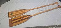 Two full-length paddles showing blades and shafts