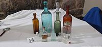 Group of all twelve antique bottles and jars arranged on table