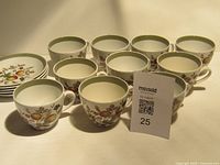 Group of ten cups with five saucers visible