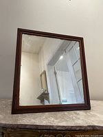 Front view of square tabletop mirror with wood frame