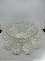 Top view of crystal punch bowl with plastic ladle and surrounding cups